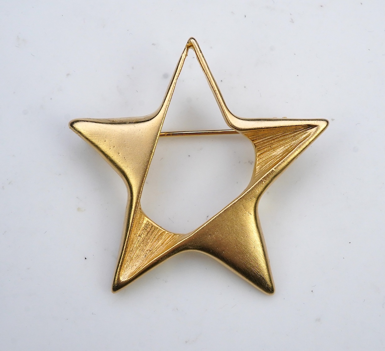 A tarnished gold star brooch in box